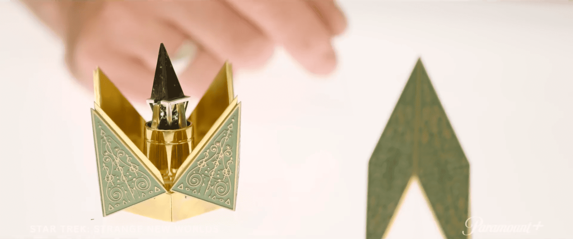 A green and gold jewelry box in this image from CBS Studios